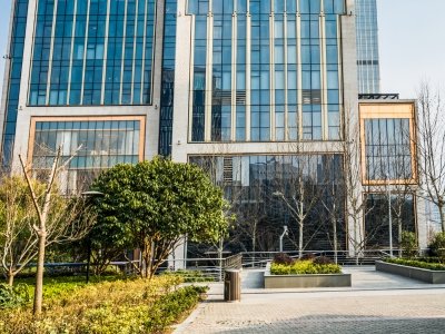 Modern commercial glass building plaza with eco-friendly landscaping