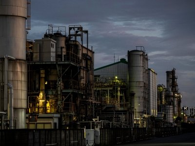 Industrial chemical plant equipment and towers lit up against a dark sky
