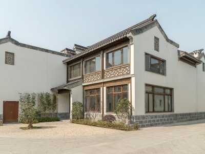 Modern villa with traditional white walls, dark trim, and landscaped courtyard